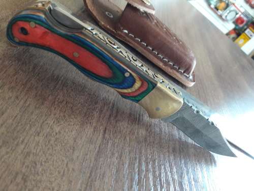Handmade Damascus steel folding knife with Wooden handle scales.