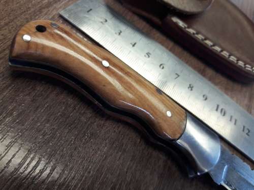 Handmade Damascus steel folding knife with Wooden handle scales.