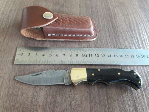 Handmade Damascus steel folding knife with Bull Horn handle scales.