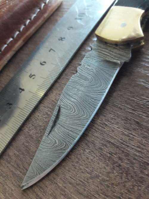 Handmade Damascus steel folding knife with Bull Horn handle scales.