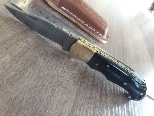 Handmade Damascus steel folding knife with Bull Horn handle scales.