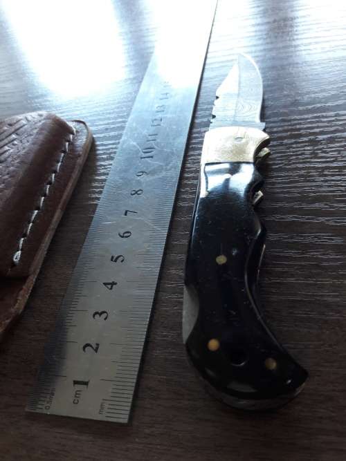 Handmade Damascus steel folding knife with Bull Horn handle scales.
