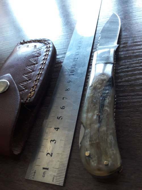 Handmade Damascus steel folding knife with RAM HORN handle scales.