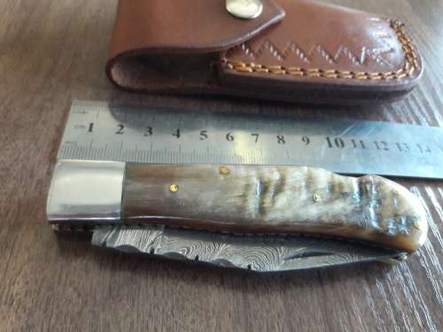 Handmade Damascus steel folding knife with RAM HORN handle scales.