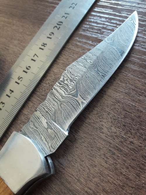 Handmade Damascus steel folding knife with Wooden handle scales.
