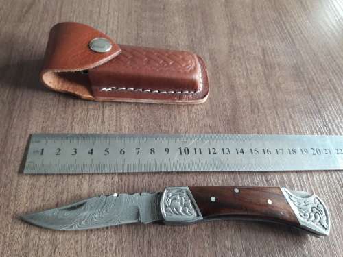 Handmade Damascus steel folding knife with Wooden handle scales.