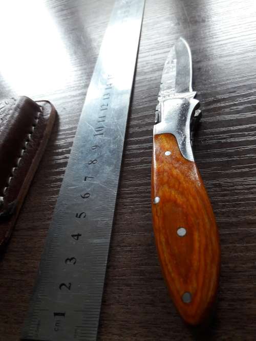 Handmade Damascus steel folding knife with Wooden handle scales.