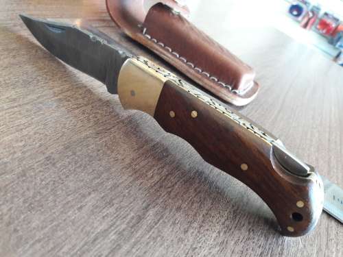 Handmade Damascus steel folding knife with Wooden handle scales.