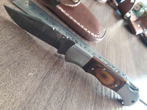 Handmade Damascus steel folding knife with Wooden handle scales.