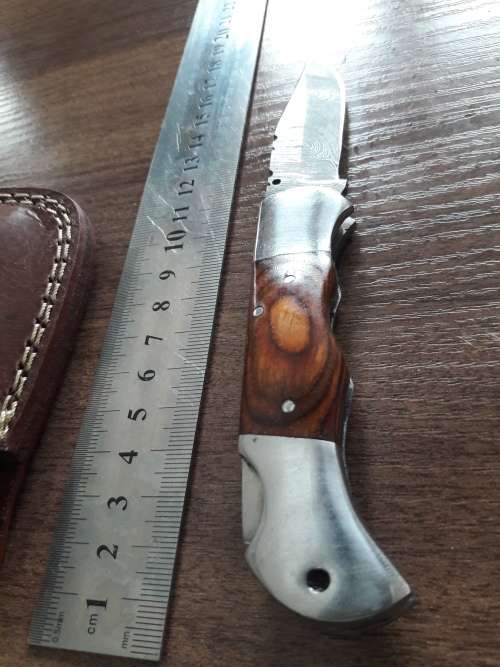 Handmade Damascus steel folding knife with Wooden handle scales.