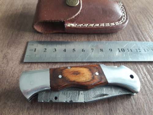 Handmade Damascus steel folding knife with Wooden handle scales.