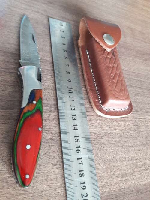 Handmade Damascus steel folding knife with Wooden handle scales.