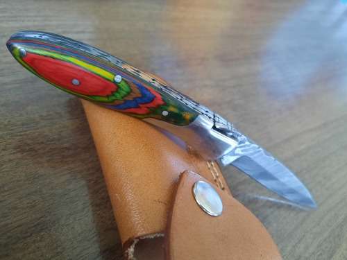 Handmade Damascus steel folding knife with Wooden handle scales.