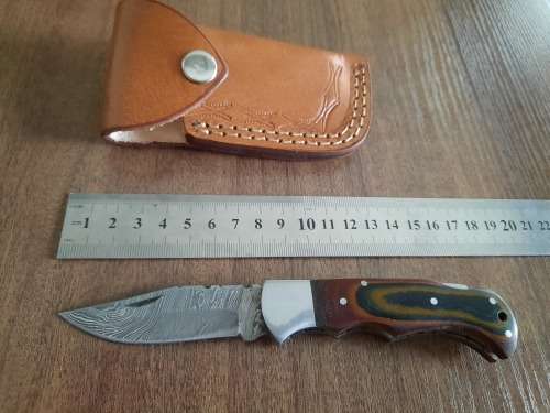 Handmade Damascus steel folding knife with MICARTA handle scales.