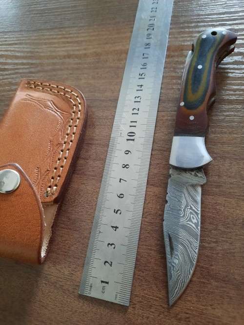 Handmade Damascus steel folding knife with MICARTA handle scales.