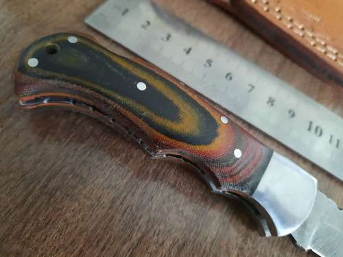 Handmade Damascus steel folding knife with MICARTA handle scales.