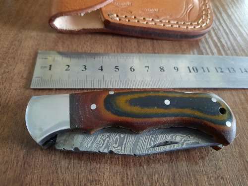Handmade Damascus steel folding knife with MICARTA handle scales.