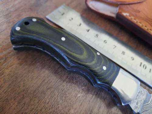 Handmade Damascus steel folding knife with MICARTA handle scales.