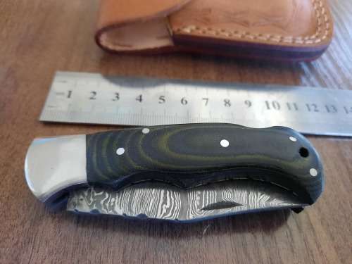 Handmade Damascus steel folding knife with MICARTA handle scales.