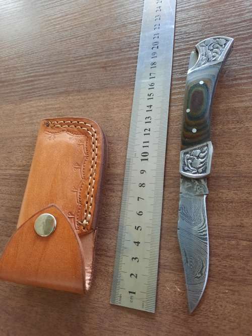 Handmade Damascus steel folding knife with MICARTA handle scales.