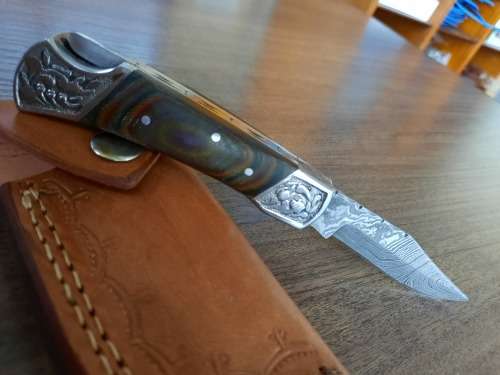 Handmade Damascus steel folding knife with MICARTA handle scales.