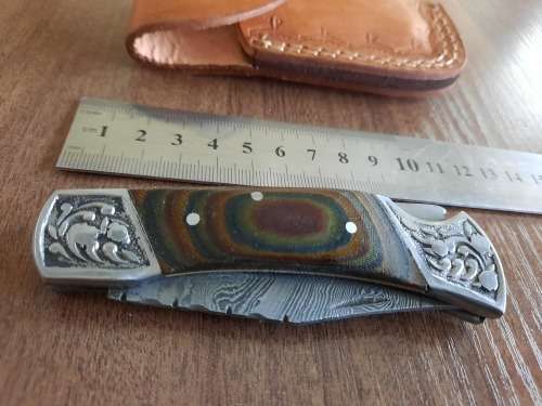 Handmade Damascus steel folding knife with MICARTA handle scales.