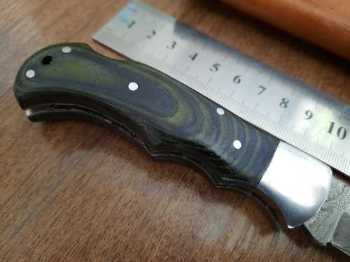 Handmade Damascus steel folding knife with MICARTA handle scales.