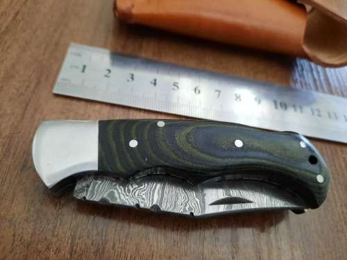 Handmade Damascus steel folding knife with MICARTA handle scales.