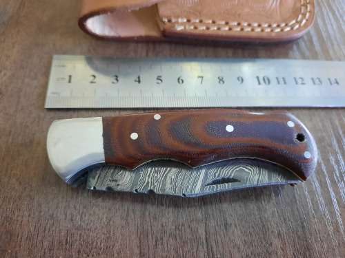 Handmade Damascus steel folding knife with MICARTA handle scales.