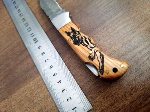 Handmade Damascus steel folding knife with wooden handle scales. Dog picture engraved. NEW STOCK !