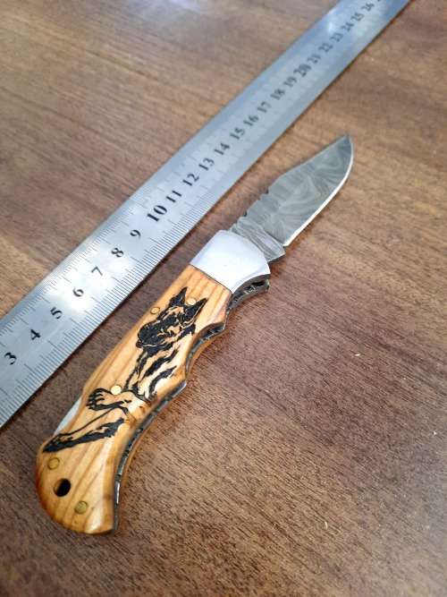 Handmade Damascus steel folding knife with wooden handle scales. Dog picture engraved. NEW STOCK !