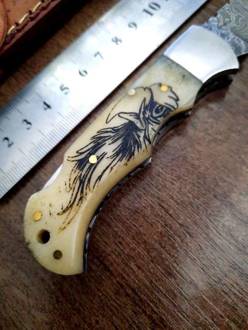 Handmade Damascus steel folding knife w Camel Bone Handle Scales. Art engraved.