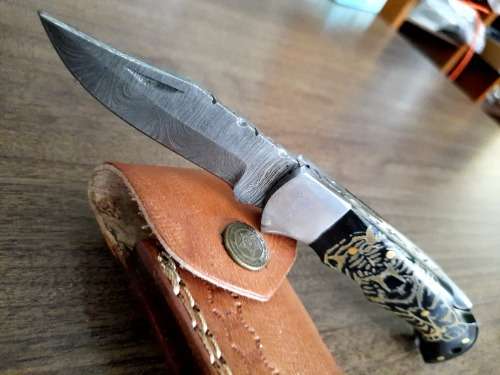 Handmade Damascus steel folding knife with Bull Horn Handle. Tiger picture engraved.