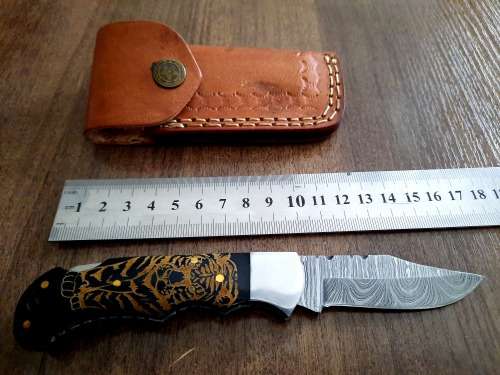Handmade Damascus steel folding knife with Bull Horn Handle. Tiger picture engraved.