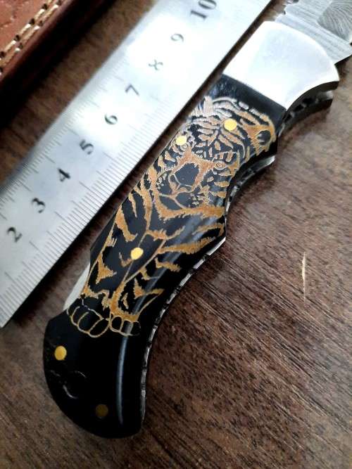 Handmade Damascus steel folding knife with Bull Horn Handle. Tiger picture engraved.