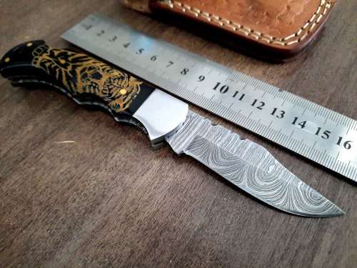 Handmade Damascus steel folding knife with Bull Horn Handle. Tiger picture engraved.
