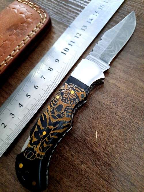 Handmade Damascus steel folding knife with Bull Horn Handle. Tiger picture engraved.