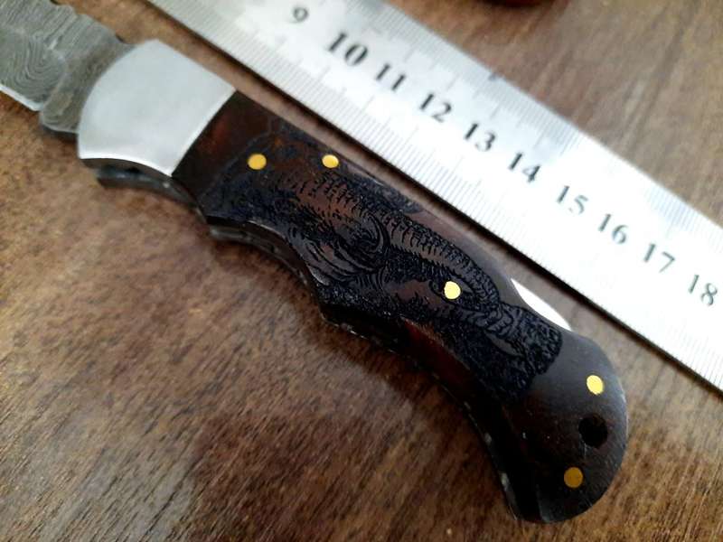 Handmade Damascus steel folding knife with wooden handle scales. Picture engraved. NEW STOCK !