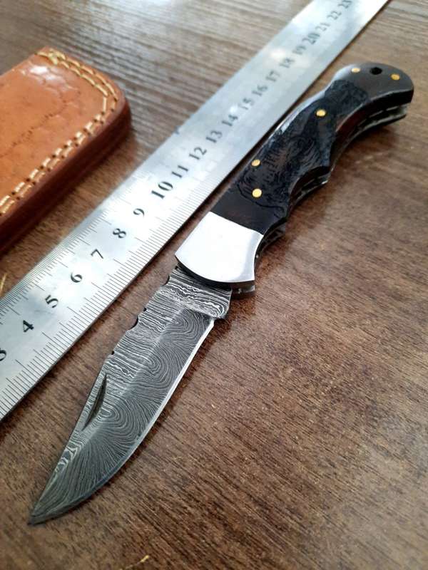 Handmade Damascus steel folding knife with wooden handle scales. Picture engraved. NEW STOCK !