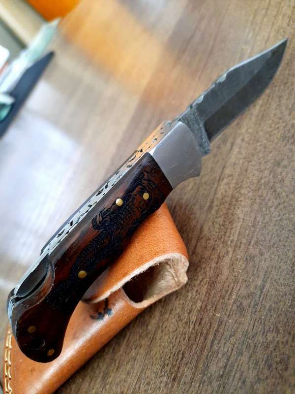 Handmade Damascus steel folding knife with wooden handle scales. Picture engraved. NEW STOCK !