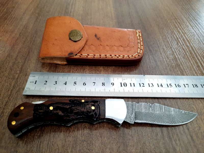 Handmade Damascus steel folding knife with wooden handle scales. Picture engraved. NEW STOCK !