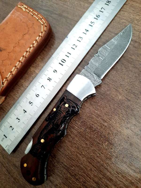 Handmade Damascus steel folding knife with wooden handle scales. Picture engraved. NEW STOCK !