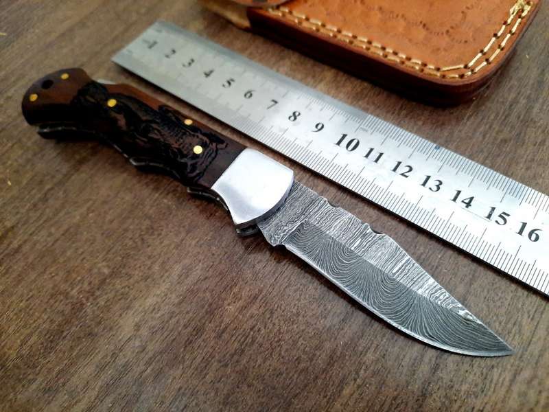 Handmade Damascus steel folding knife with wooden handle scales. Picture engraved. NEW STOCK !