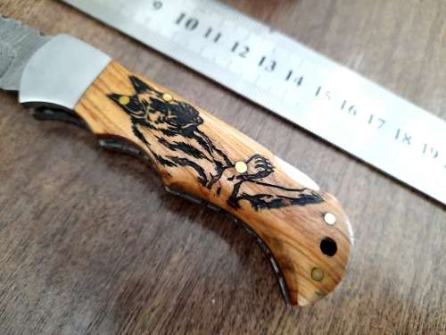 Handmade Damascus steel folding knife with wooden handle scales. Picture engraved. NEW STOCK !