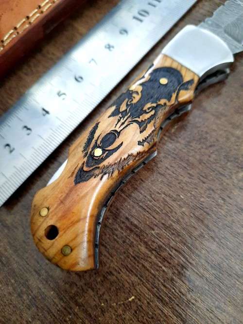 Handmade Damascus steel folding knife with wooden handle scales. Picture engraved. NEW STOCK !