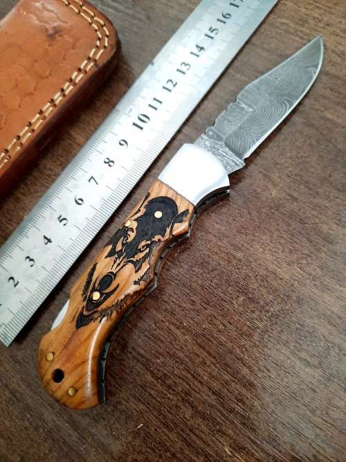 Handmade Damascus steel folding knife with wooden handle scales. Picture engraved. NEW STOCK !