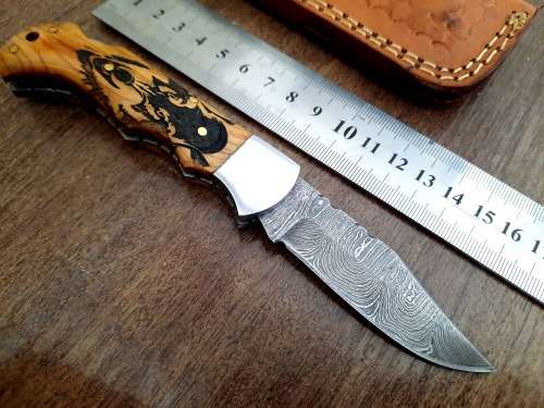 Handmade Damascus steel folding knife with wooden handle scales. Picture engraved. NEW STOCK !