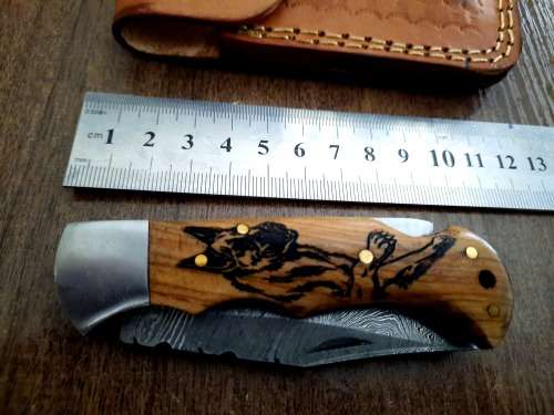 Handmade Damascus steel folding knife with wooden handle scales. Picture engraved. NEW STOCK !