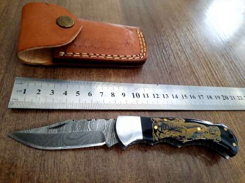 Handmade Damascus steel folding knife with Bull Horn Handle. Art engraved.