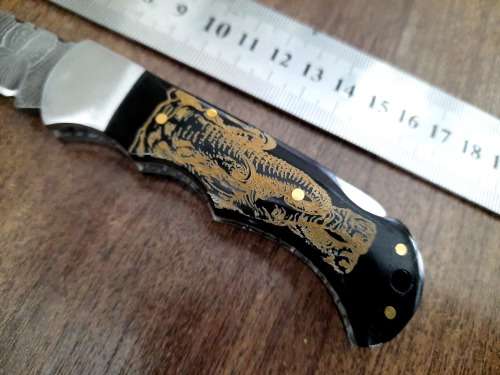 Handmade Damascus steel folding knife with Bull Horn Handle. Art engraved.